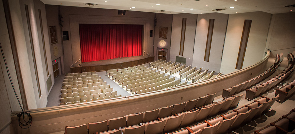 large auditorium with stage, lower level seating and upper balcony seating