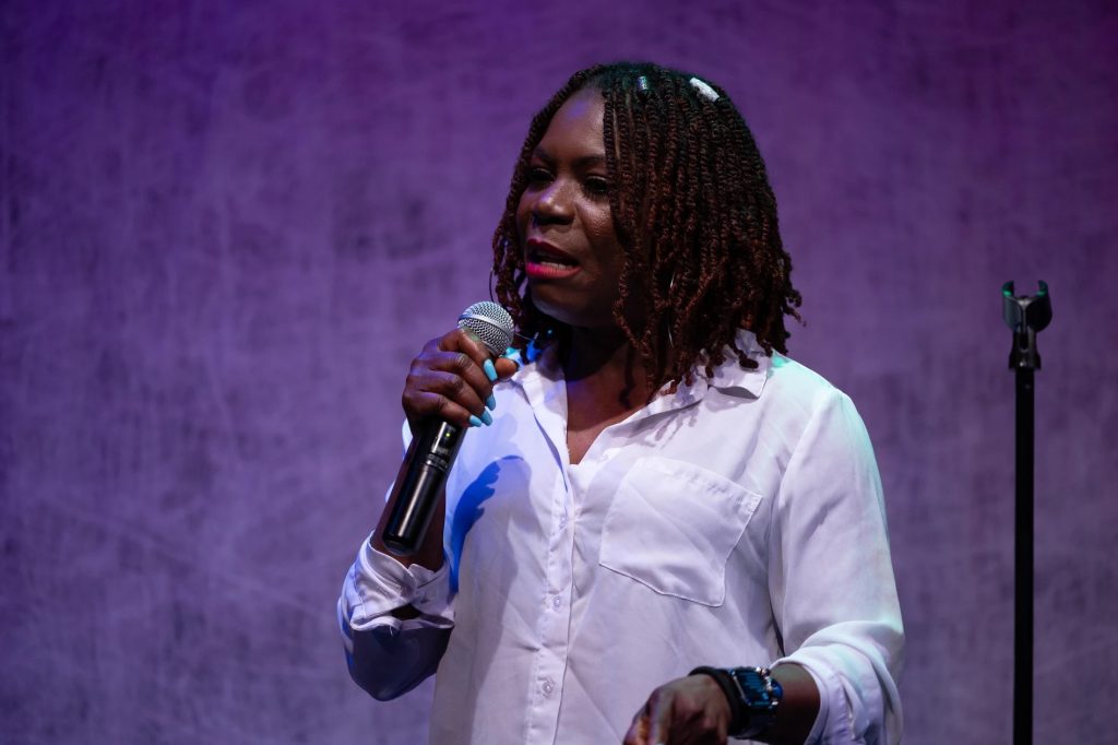 A woman talking with a microphone in hand.