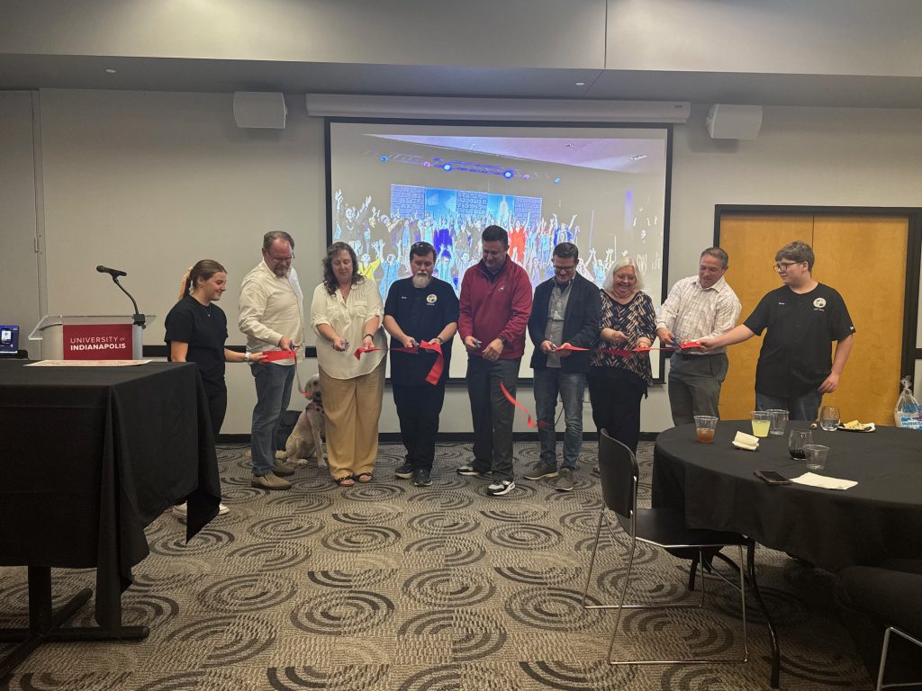 Group of people cutting a ribbon.